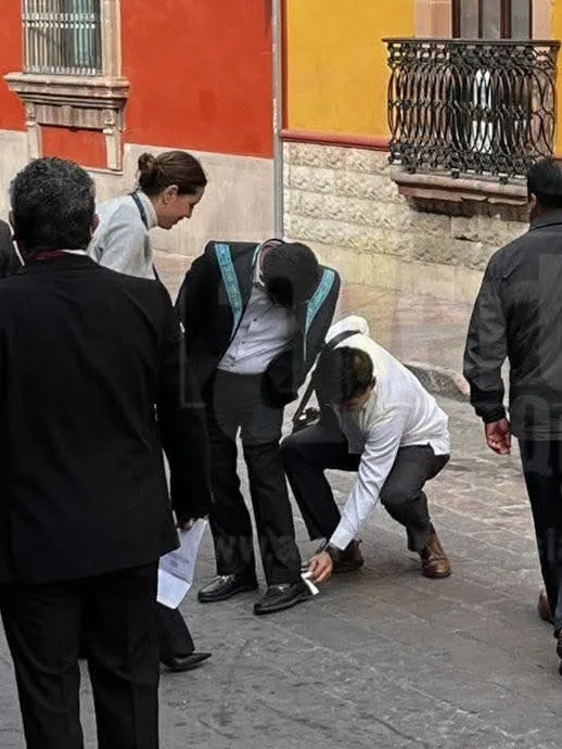 Mujer limpia los zapatos del Presidente del SCJN